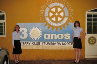 Katie Tauer and Pamela Thompson pose by a Rotary Club sign in Itumbiaria before giving our presentation in Portuguese. 