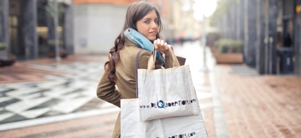 Woman walking down the street while holding 2 shopping bags