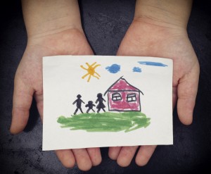 someone holding a drawing of a house