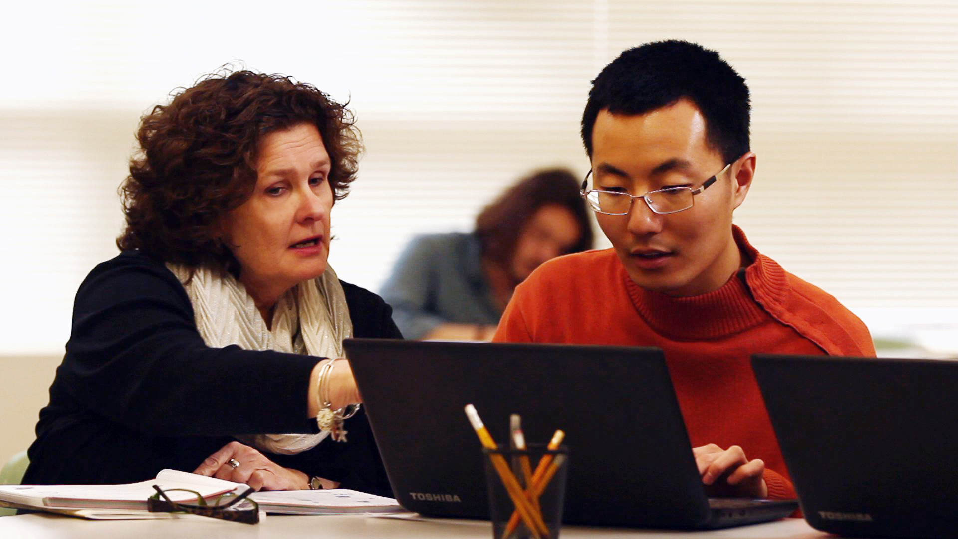 Candice helps Karl use the laptop.