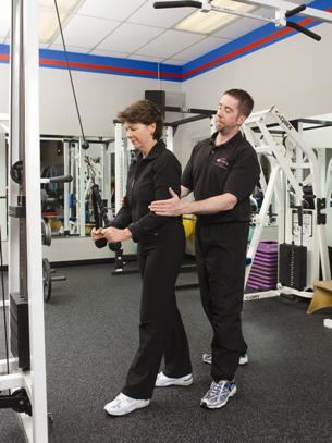 PTP New Canaan personal fitness trainer assisting a client with lat pulldown exercises