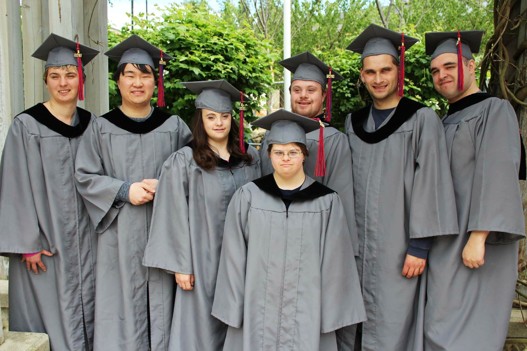 2016 Kach Graduates stand in cap and gown on graduation day.