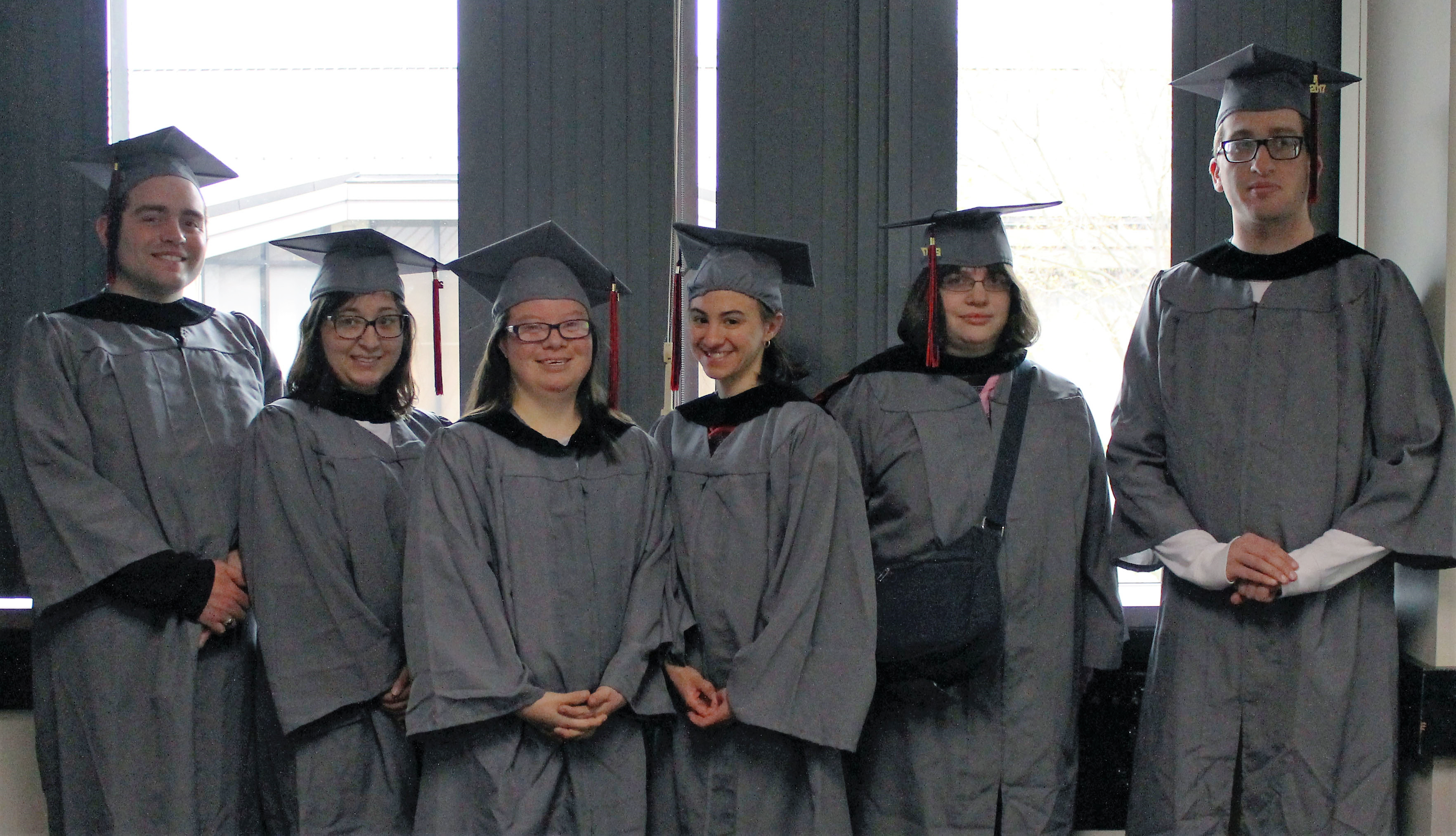 2017 Kach Graduates stand in cap and gown on graduation day.
