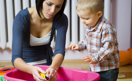 Child and Childcare Provider Playing with Toys