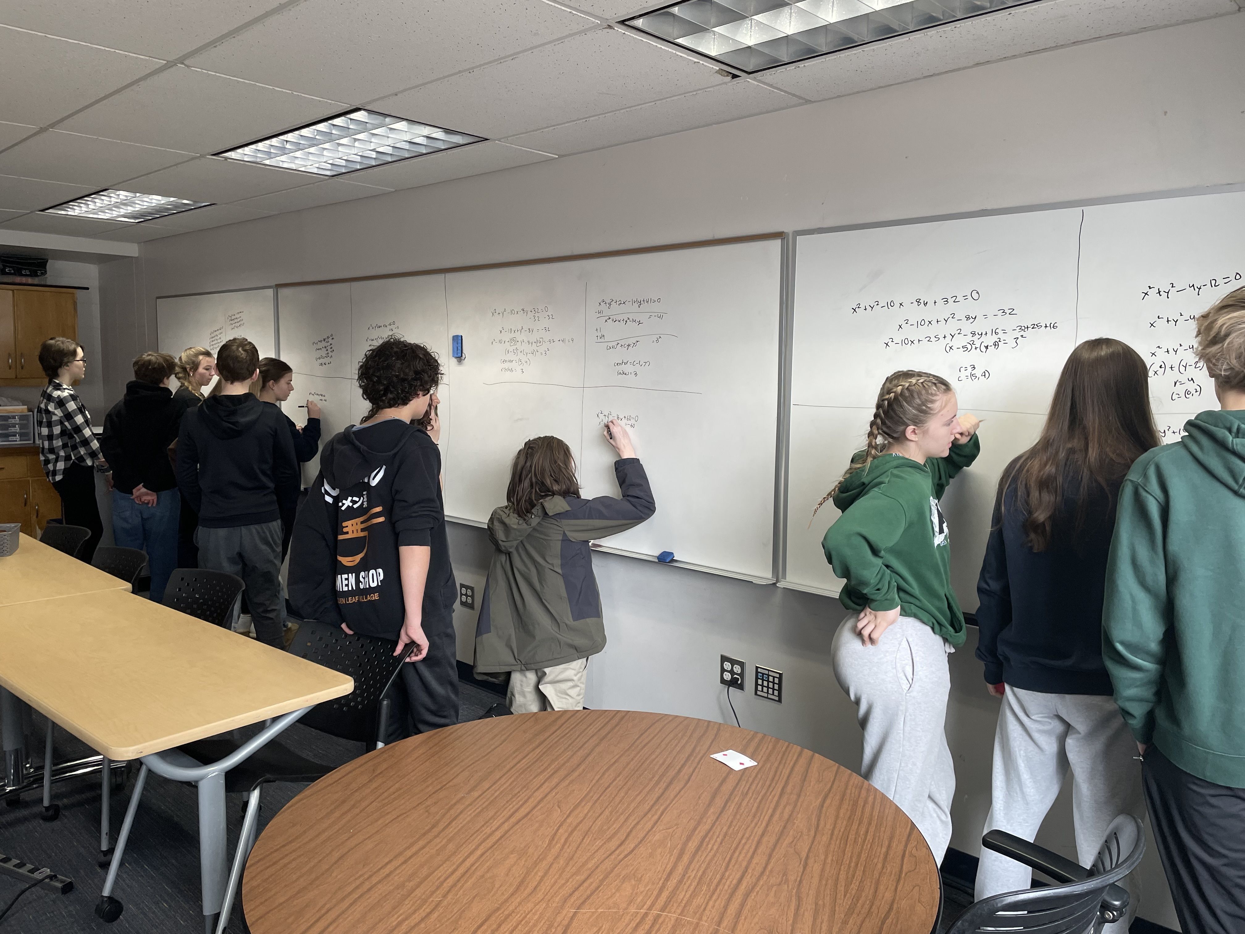 students standing at whiteboards