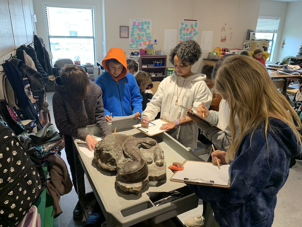 Students studying a 3d hellbender statue