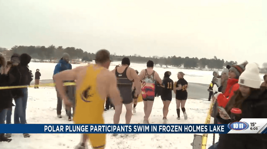 Polar Plunge participants swim in frozen Holmes Lake