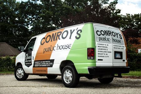 White panel van with brown and green graphics with word Conroy's in black capital letters