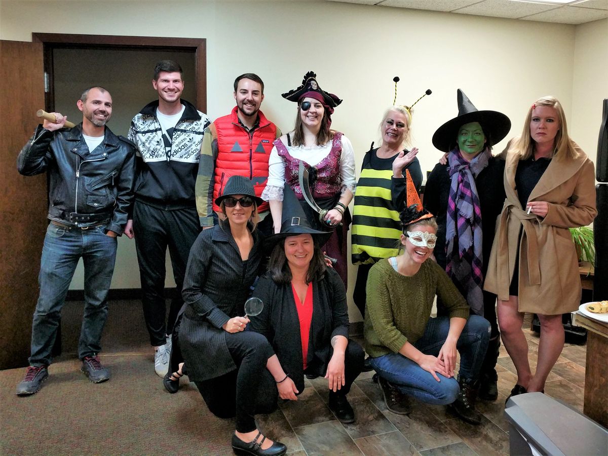 [Image Description: Staff pictured for a Halloween photo, all wearing different attire and smiling.]