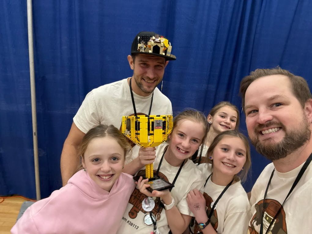 girls with FIRST Lego league trophy