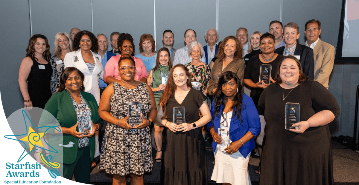 women posing on a stage holding awards