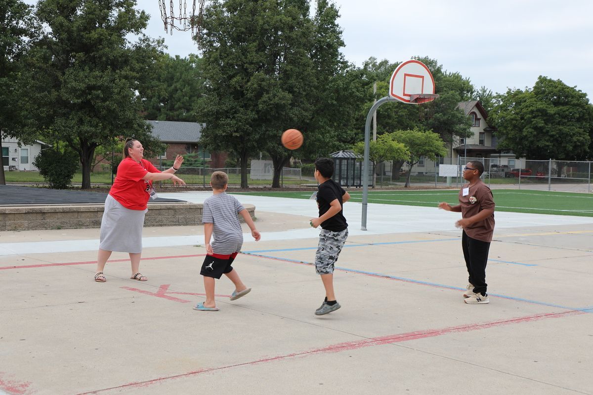 3 students and one teacher playing basketball