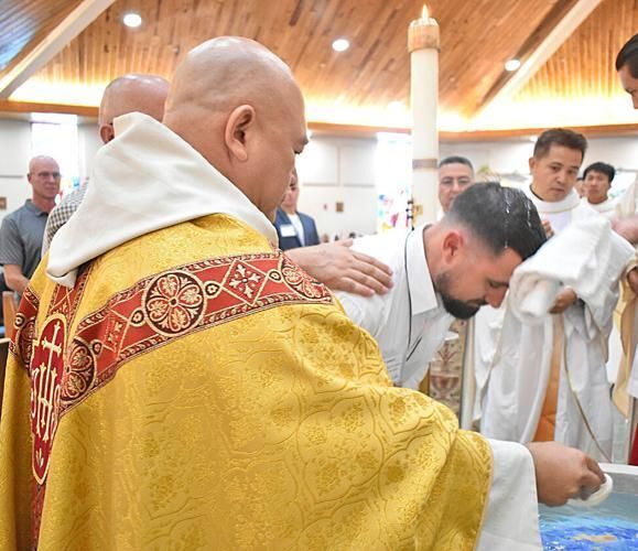 Father Tri Pham, pastor of Holy Family Parish, administers the sacrament of baptism to catechumen Shawn Bonnie at the Easter Vigil.