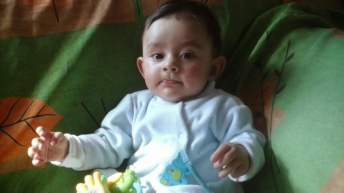toddler girl with ponytails splashes in water