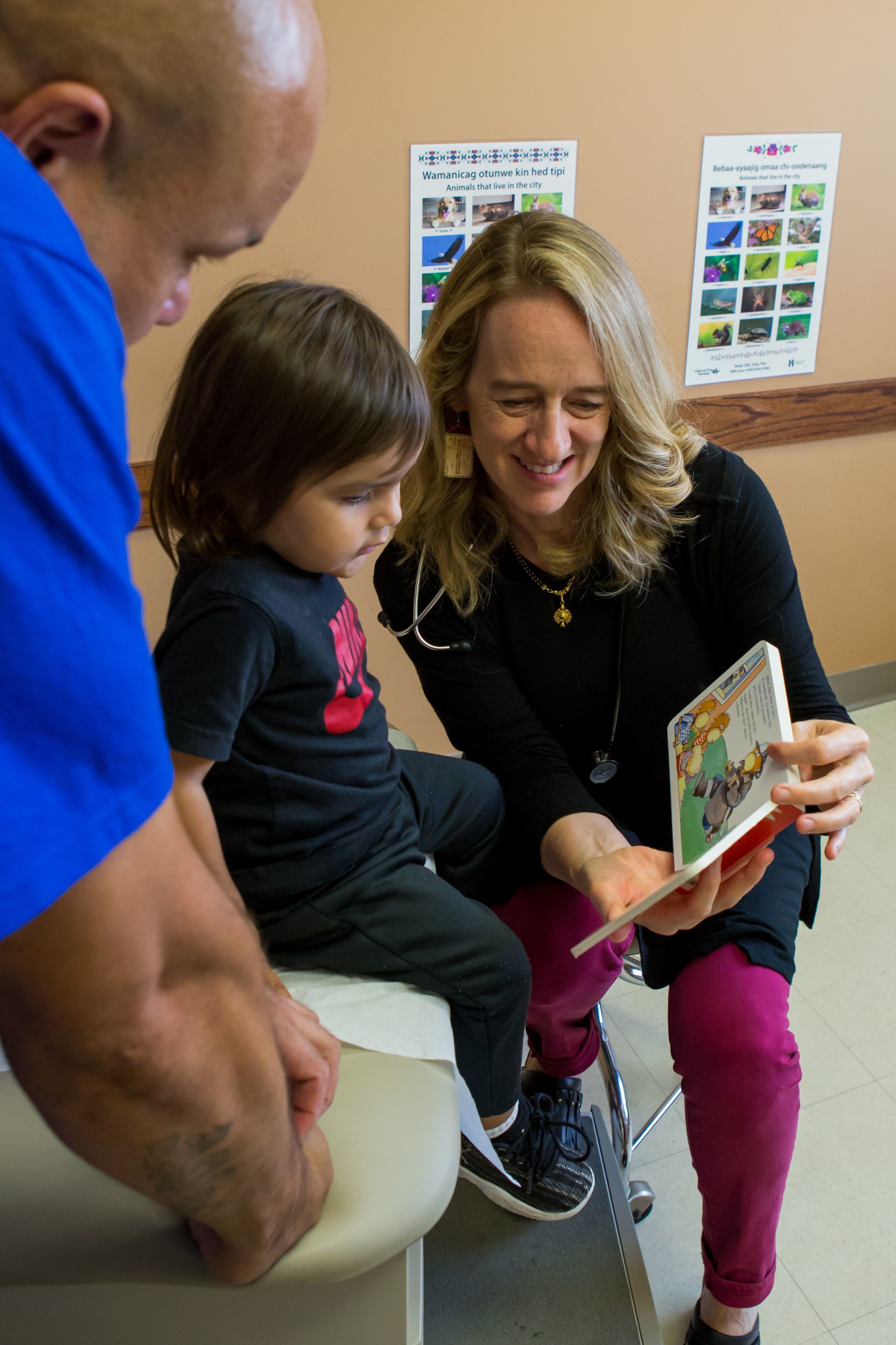 Dr. Erdrich shares book with toddler boy and father