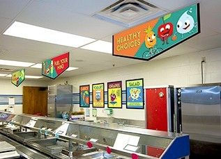 Elementary school café serving line with 3 nutrition education banners hanging above