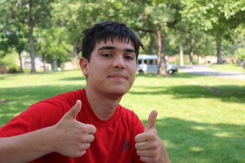 A camper poses for a photo with his thumbs up.