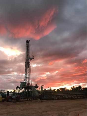 Oil rig with a pink sunset in the background.