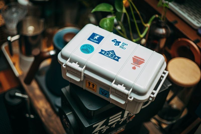 Coffee gear case covered in specialty roaster stickers, an example of sticker marketing used by coffee brands to build community.