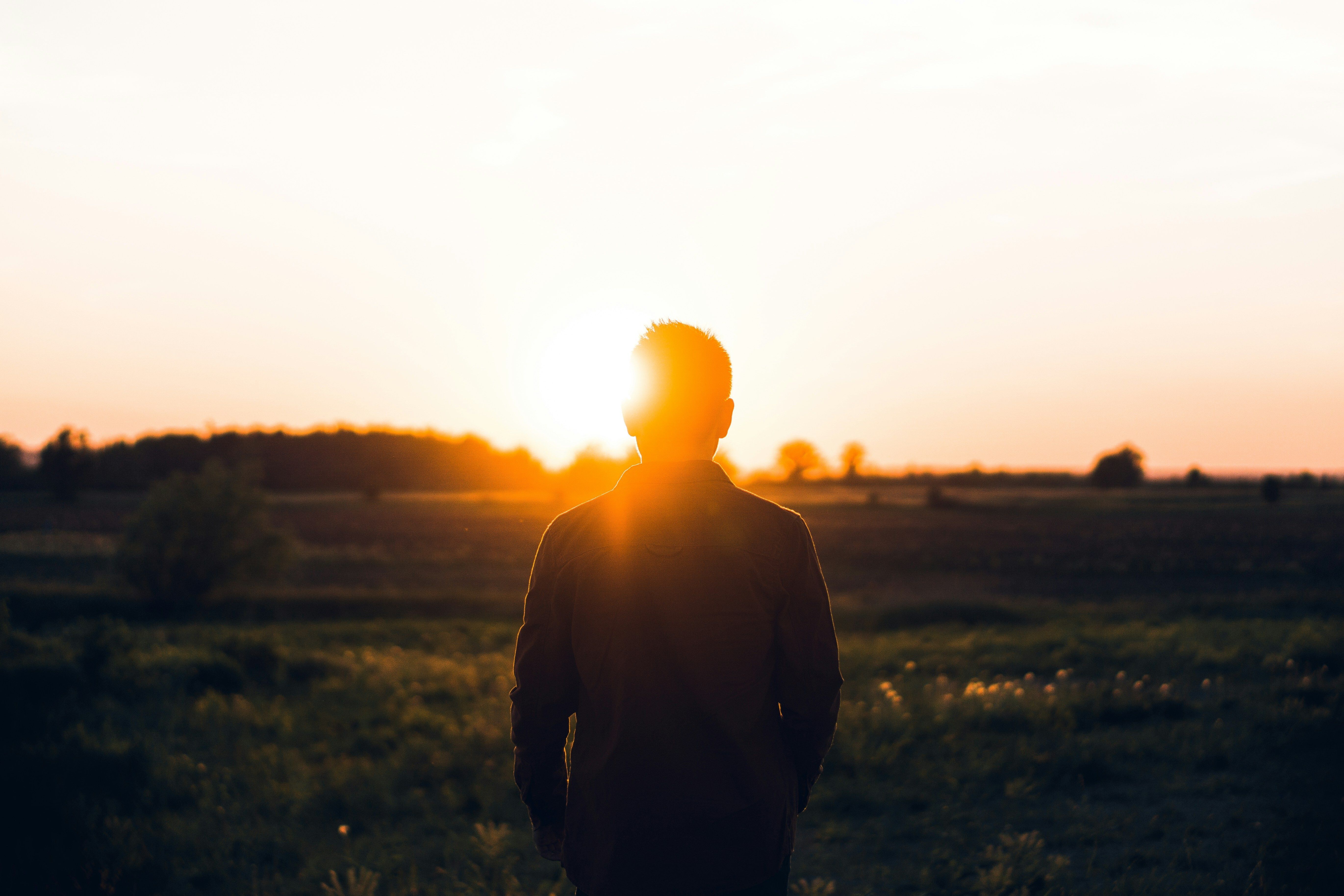 Man standing outside watching sunset