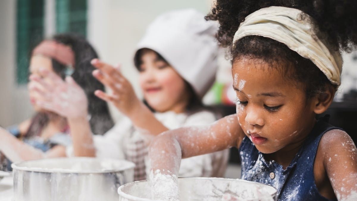 young children cooking with chef hats on