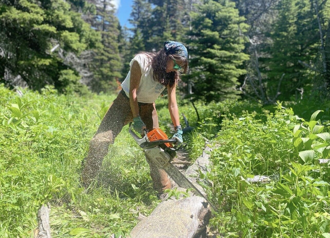 Rosy saws a log during her summer on the Glacier National Park trail crew.