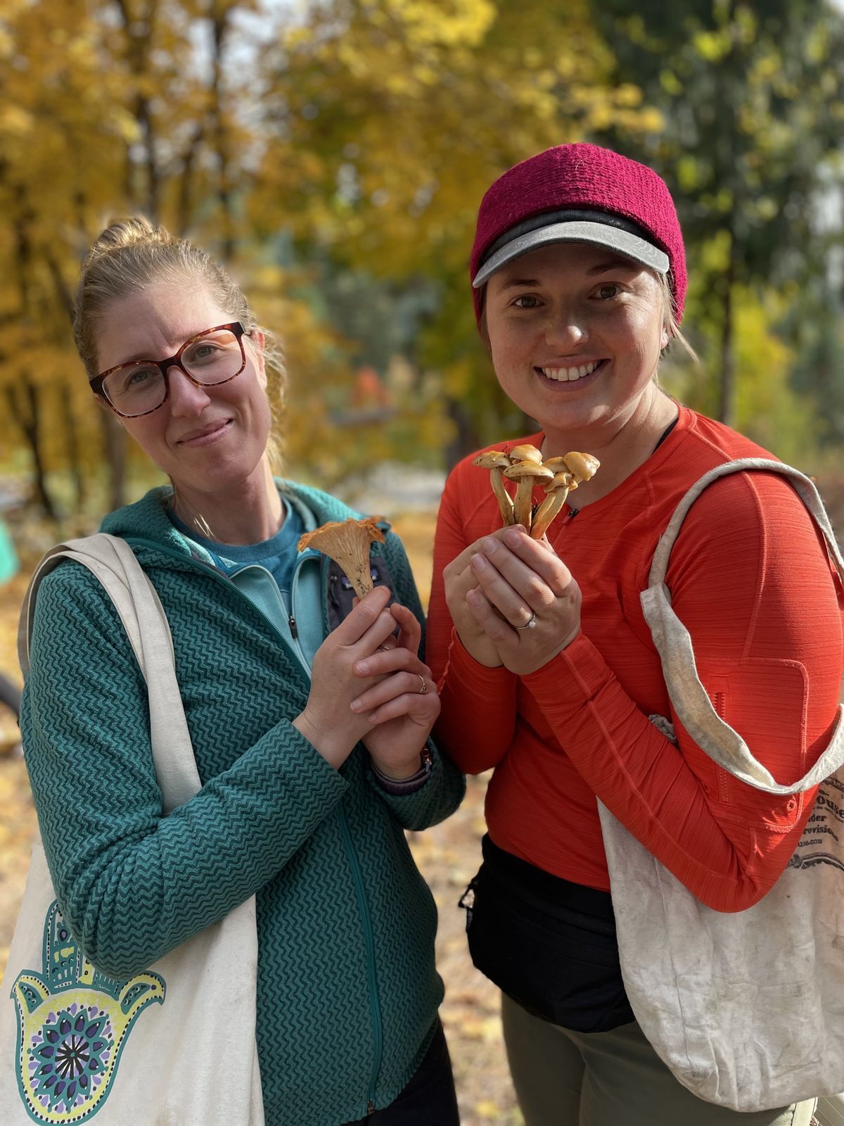 Two participants posing for the camera with some mushrooms they found on the Fungi Field Trip.