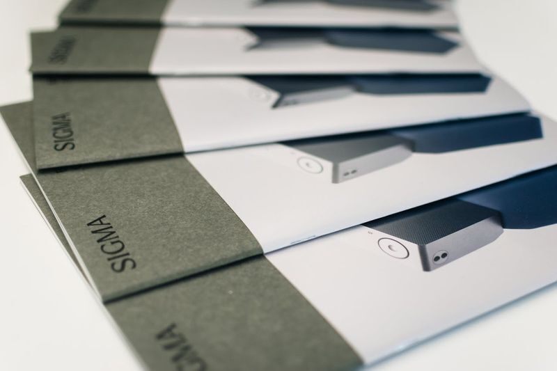 Stack of brochures with a uniform grey edge. Maintaining exact brand colors here shows why color management is vital for physical marketing.