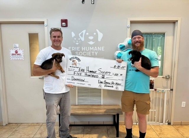 Men with puppies holding a large check