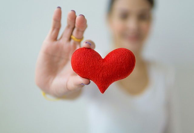 Close-up of person holding a red fabric heart.