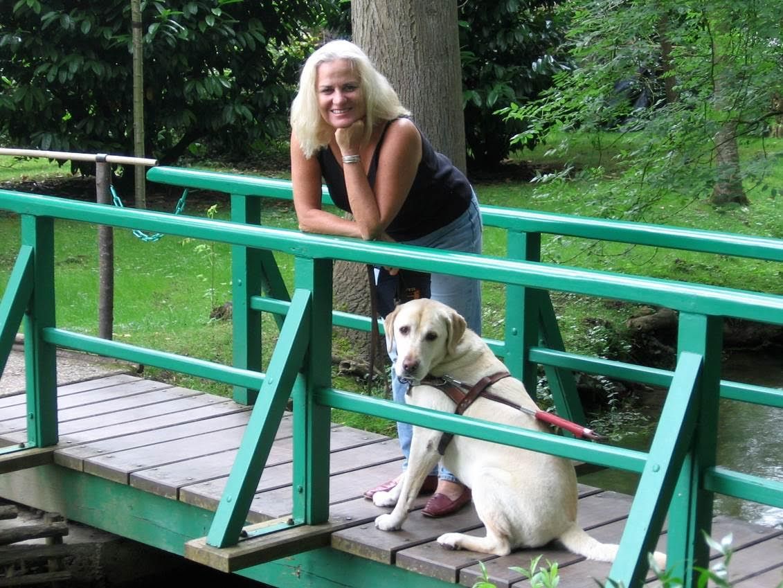 Moira and her dog Finnegan leaning against a green railing