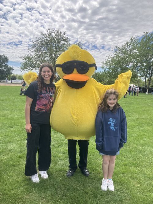 Picture of two women posing with a person dressed in a yellow rubber ducky costume