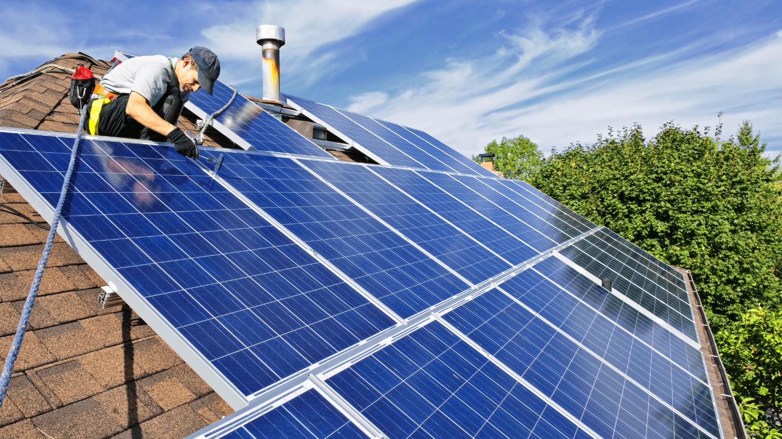 Man installing solar panels on rooftop