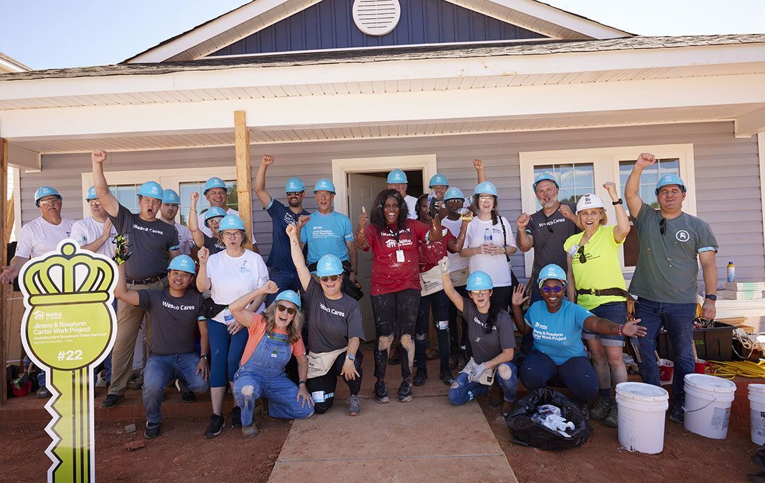 Volunteers celebrating in front of new habitat home.