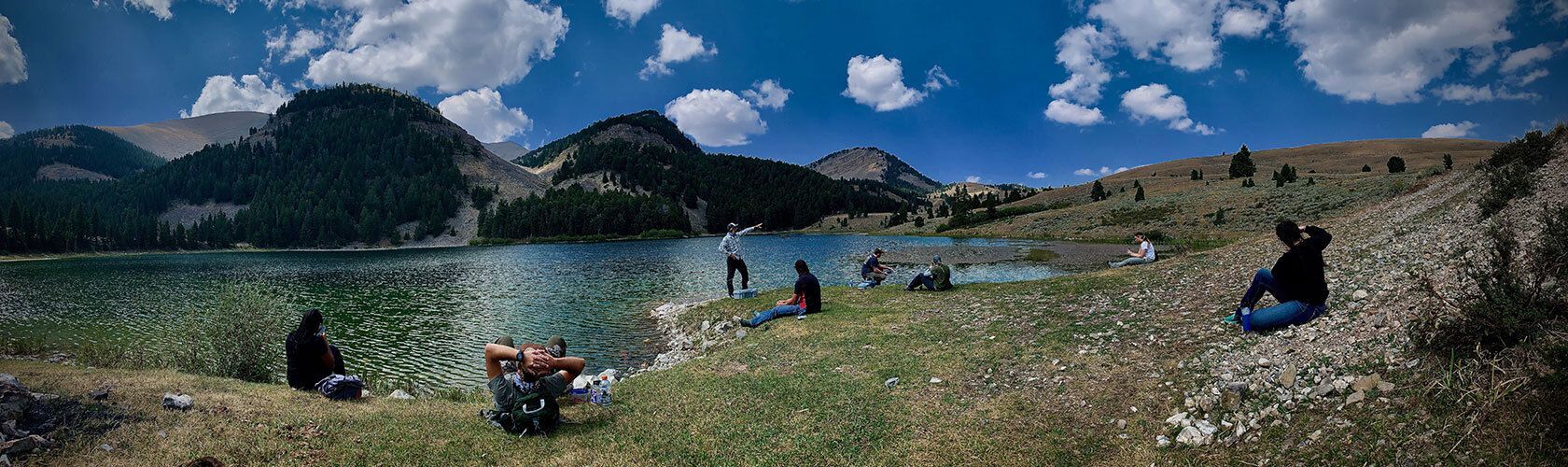 Students relaxing by a stunning lake.