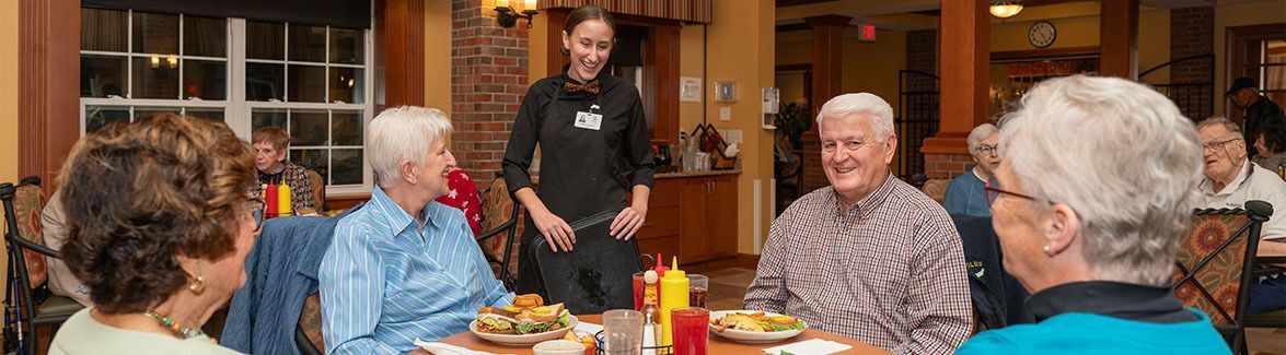 Server interacting with residents in the Bistro