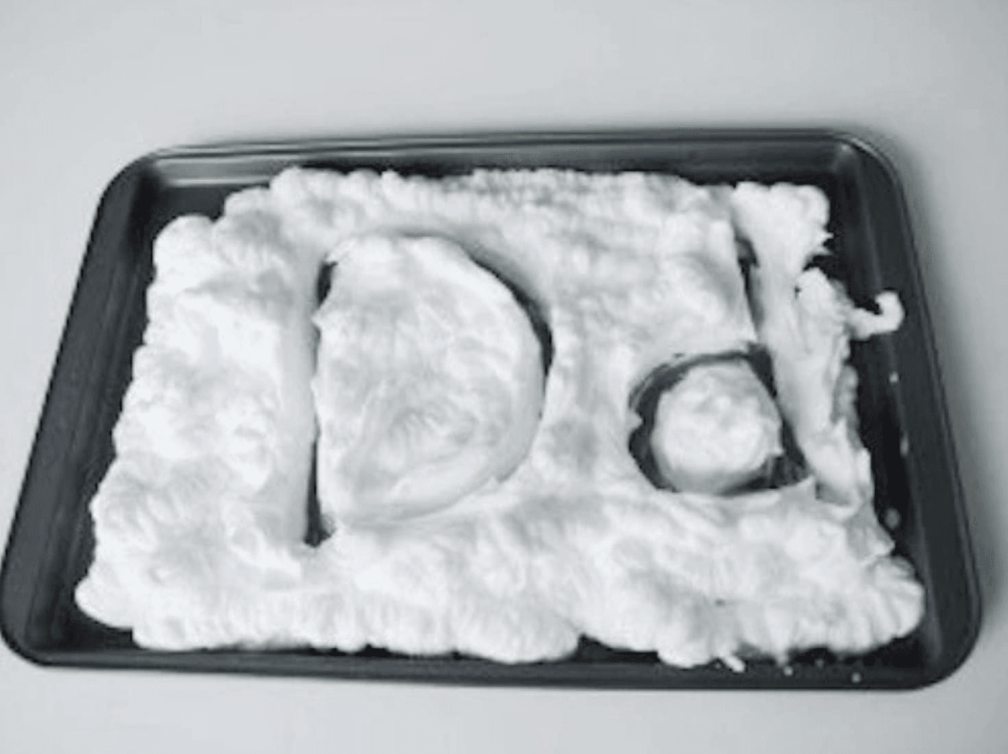 upper and lower case letter "d" written in shaving cream on a tray