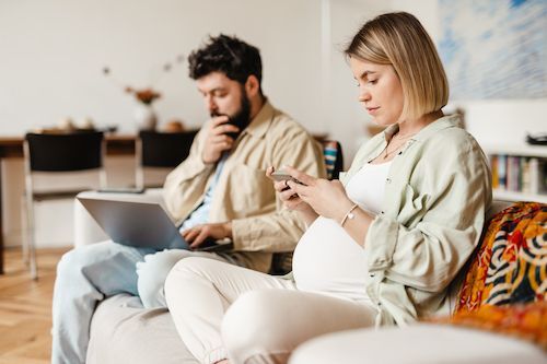 Mom to be on her phone completing a self-screening tool