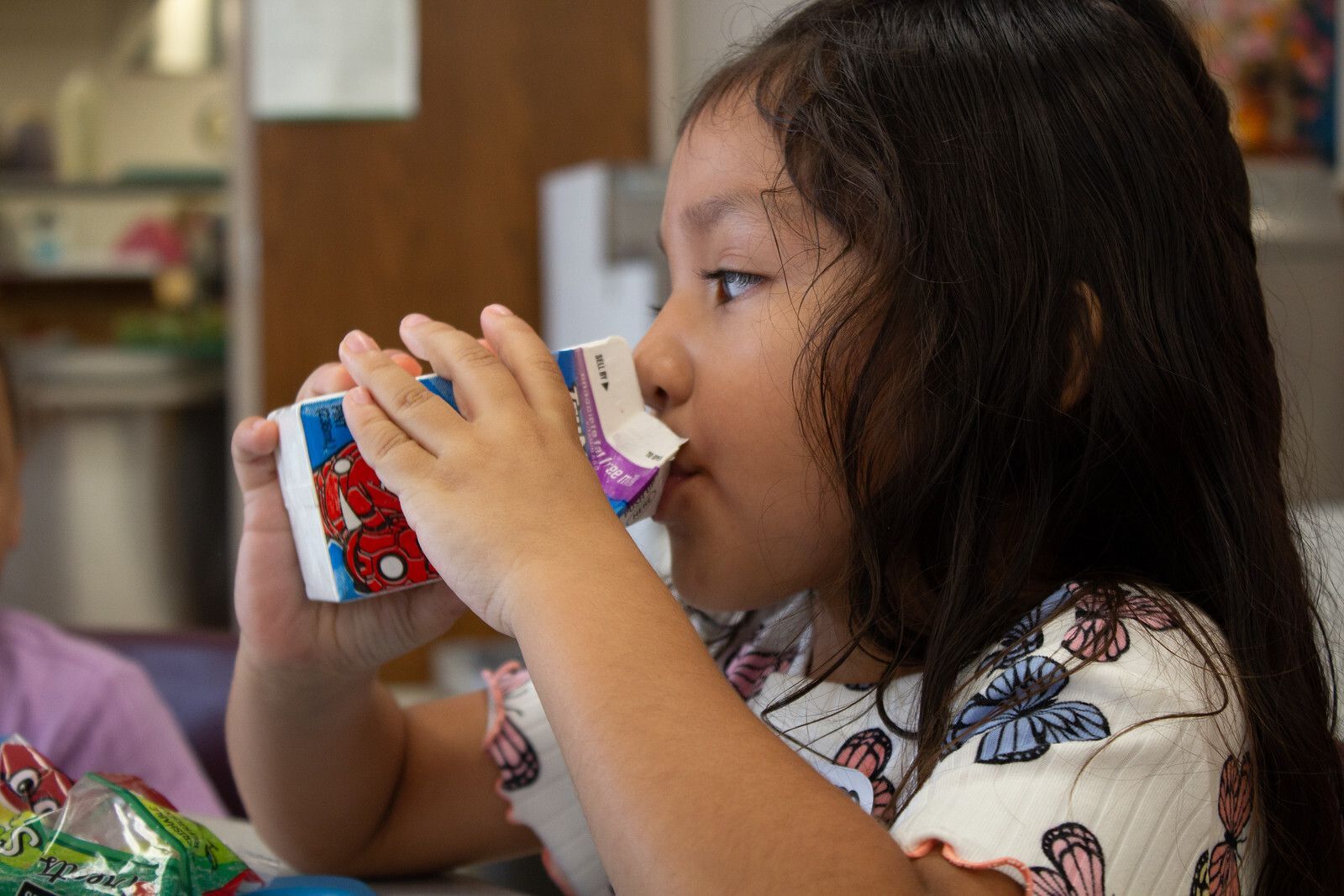two elementary students eating lunch in a school cafeteria