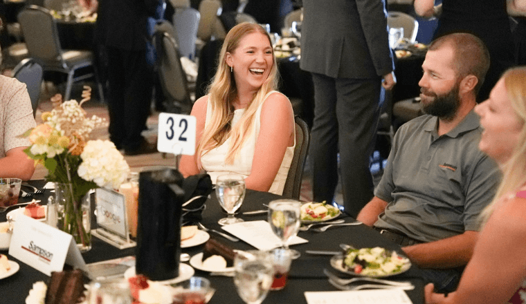 Attendees laughing at their table at the 2025 Back to School Soiree