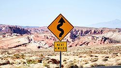 Road sign in the desert that says Next 4 Miles.