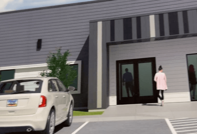 A fake photo of what the new Crisis Stabilization Unit building will look like with people and a car outside of it. 