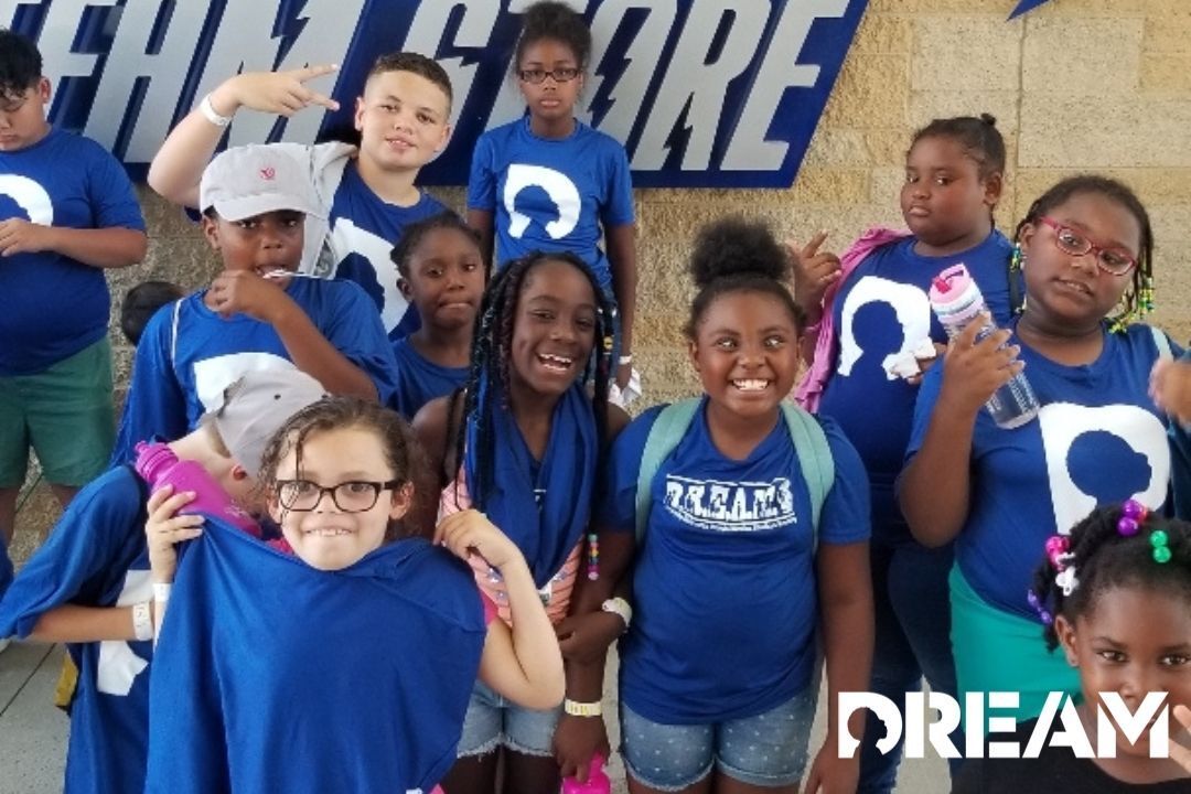 Young children wearing blue DREAM shirts and smiling