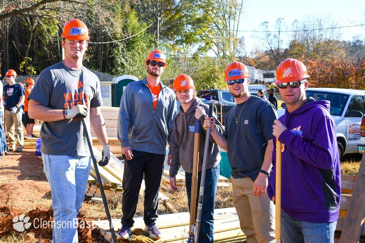 Clemson University Baseball players pose together on a construction site holding shovels.