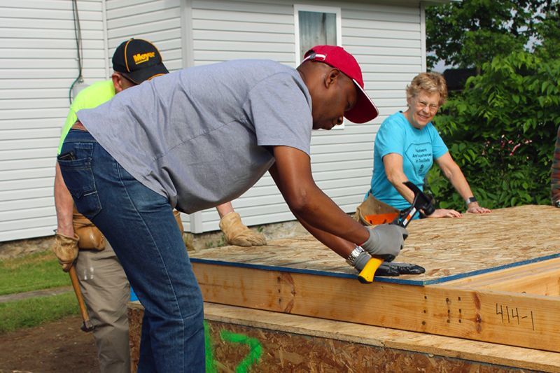 Daniel drives a nail into what will soon be the first home that he will have ever owned.