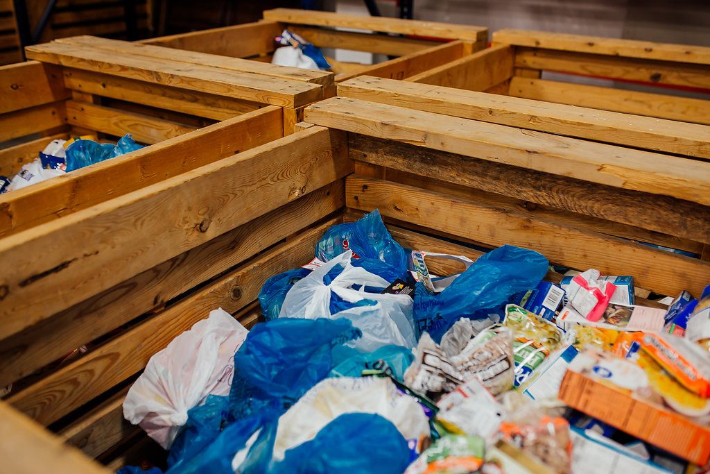 Four crates with plastic bags of food for sorting.
