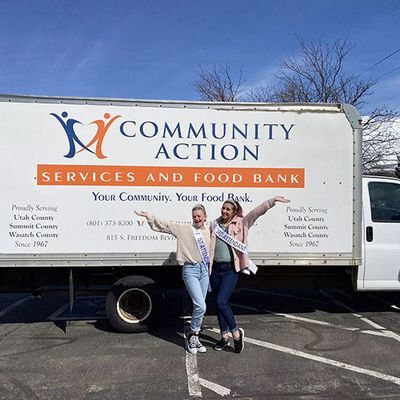 Two girls posing in front of the food drive truck.