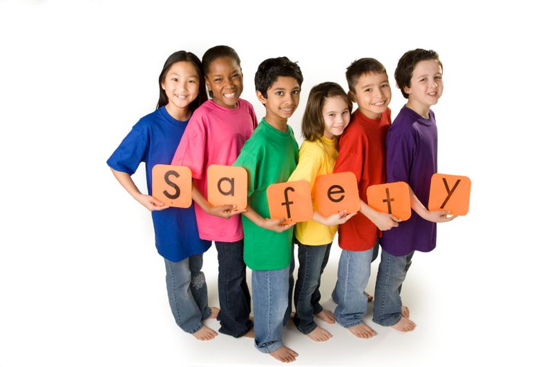 Kids in bright colored tshirts holding letters spelling safety.