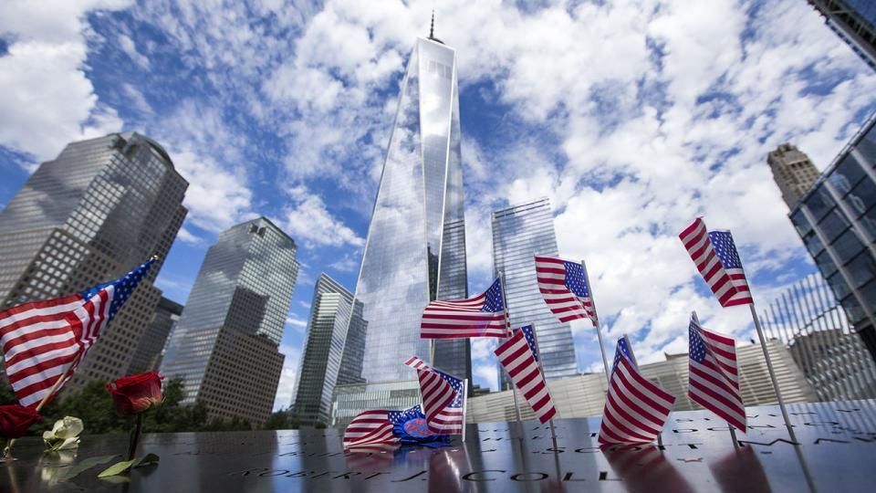 Photograph of Freedom Tower and the surrounding New York City skyline between memorial flags at the 9/11 Memorial and Museum