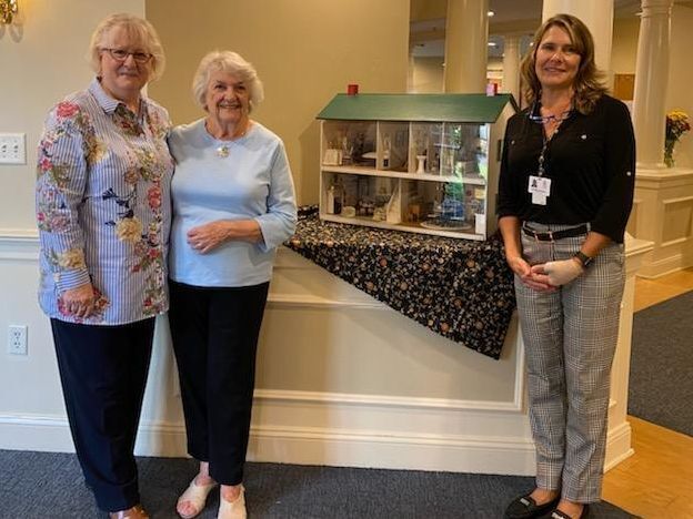 Linda Estes, Dolores Lambert, and executive director, Antoinette Wallace stand beside donated dollhouse